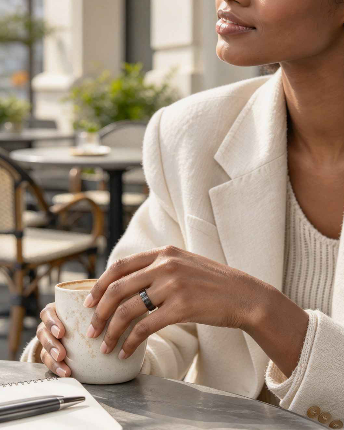 Woman wearing a GemRing while holding a coffee cup at a café.