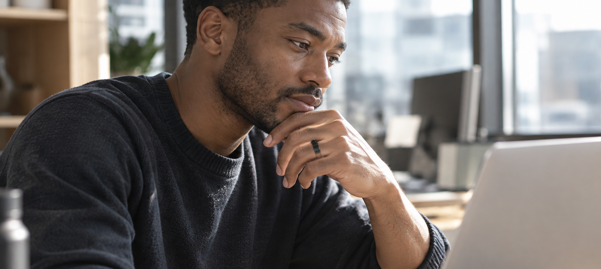 Man wearing a GemRing while working on a laptop in an office.